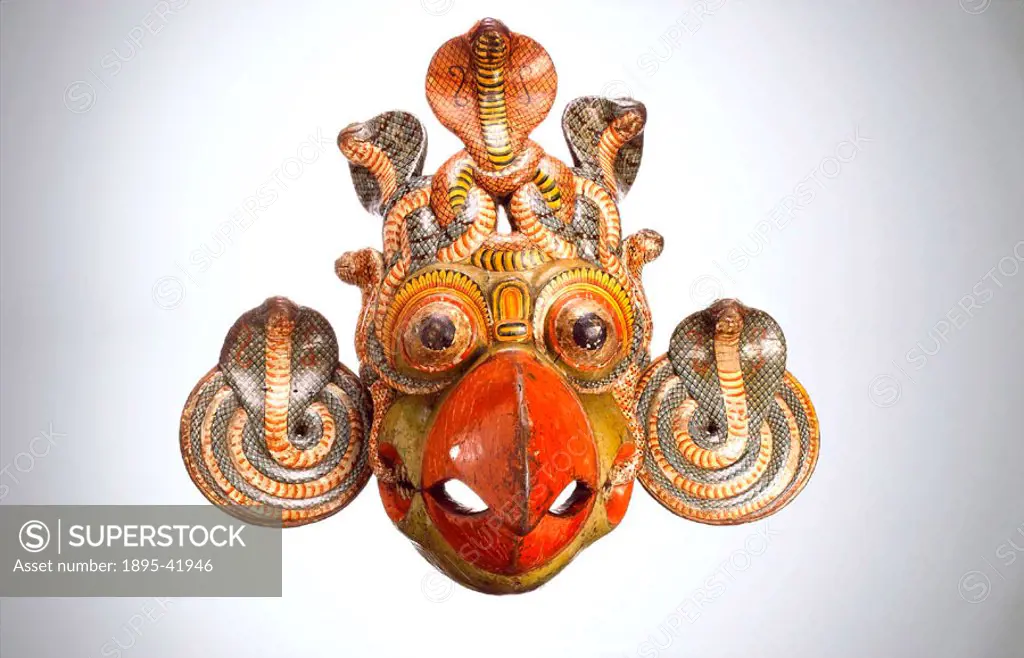 Painted wooden polychrome mask with coiled cobra disc ear-pieces and cobra headdress representing the beaked gurula, associated with kolam performance...