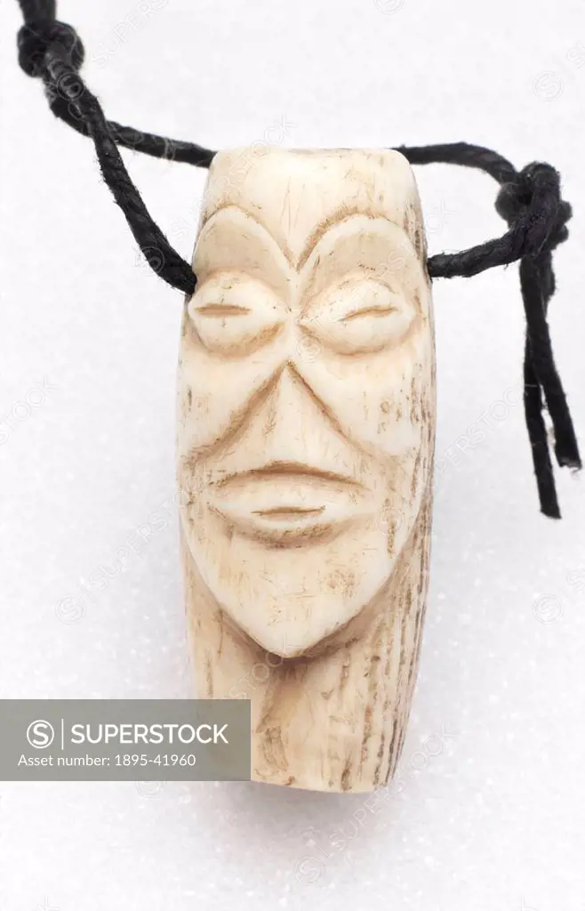 Carved ivory amulet in the form of a face, from Kasai, Zaire.