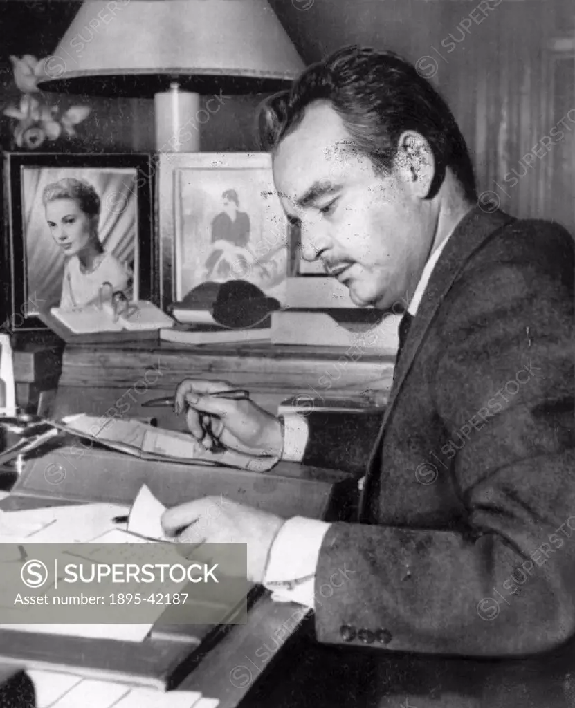 Prince Rainier (1923-2005) writing at his desk, just a few days before his marriage to American film star Grace Kelly (1929-1982). She became Princess...