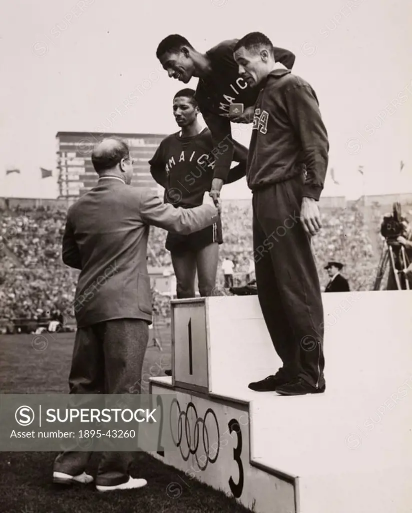 The victory ceremony after the final of the 400 metres with Arthur  Wint (Jamaica) receiving his Olmpic medal, and H. H McKenley (Jamaica) who came s...