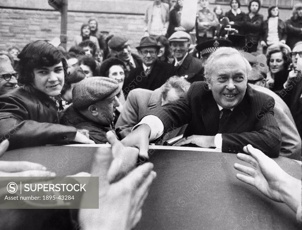 Wilson shakes hands over a car roof in the crush. Wilson (1916-1995) was born in Huddersfield and was one of the longest serving Labour Prime Minister...