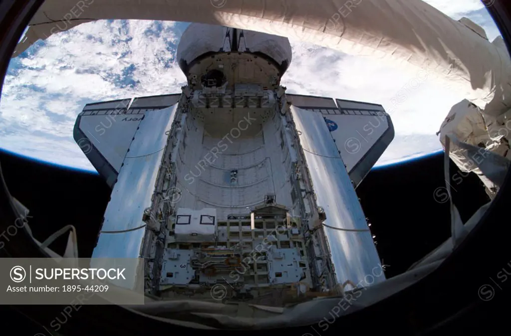 A camera on the International Space Station captured this image of the docked Space Shuttle Discovery´s payload bay, with Earth in the background. The...