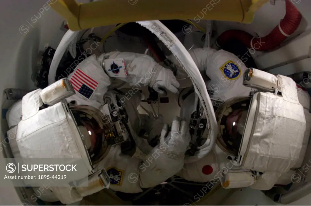 In the Space Shuttle Discovery´s airlock, astronaut Steve Robinson, left, and Japan Aerospace Exploration Agency astronaut Soichi Noguchi prepare for ...