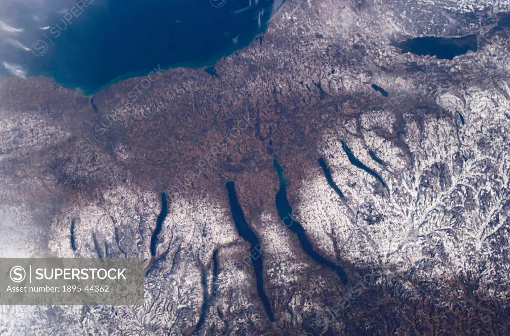 New Yorks Finger Lakes region is seen in this image from the International Space Station. Shapes of the snow-covered hills are accented by the low su...