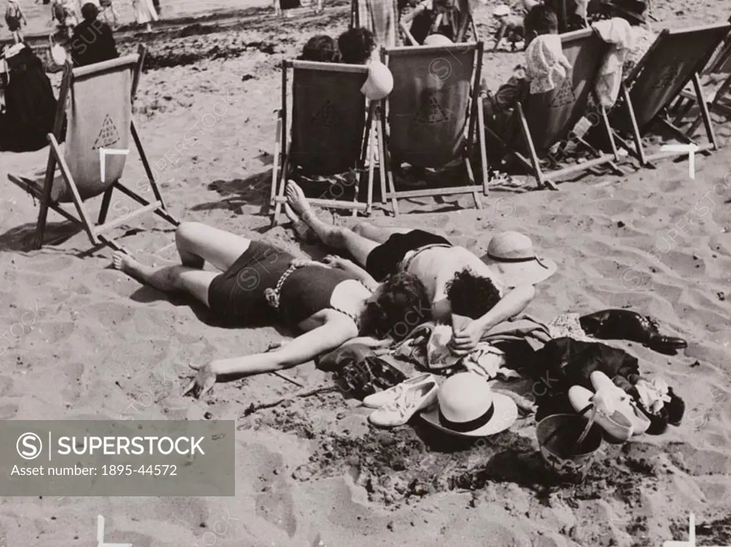 A couple sunbath on the beach on a summer day in 1936.