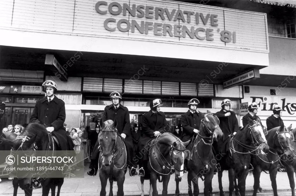 Mounted police outside the Tory party venue. Both police officers and horses have protective visors.