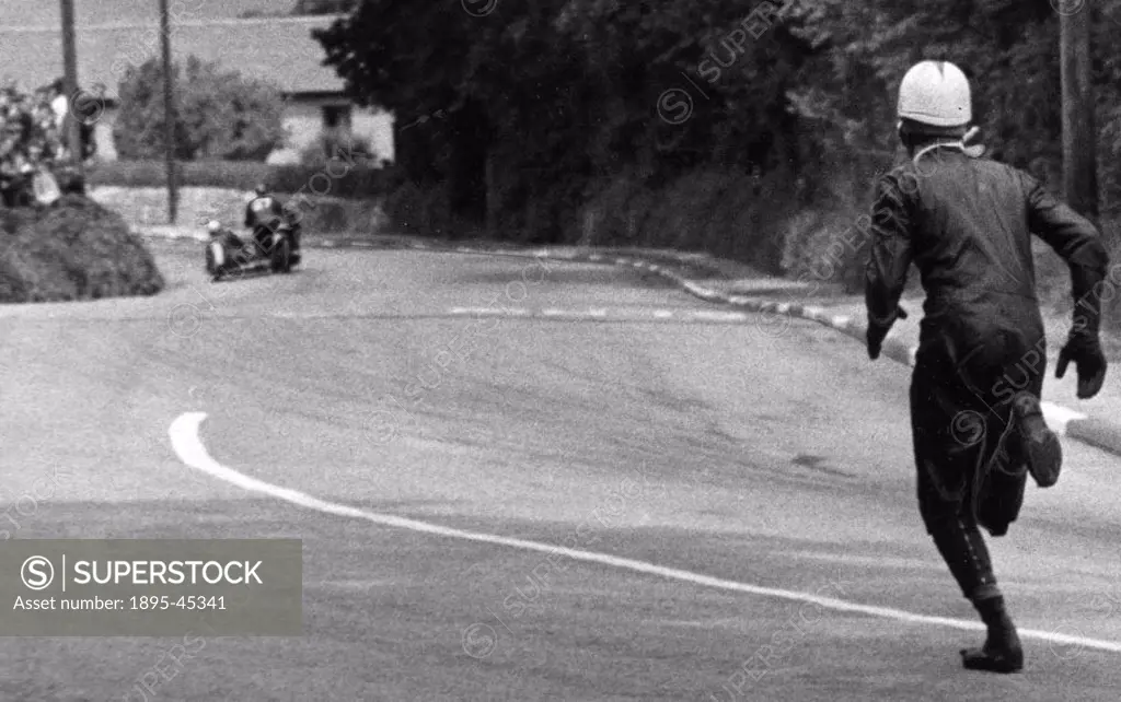 Sidecar passenger Don Simpson of Sheffield runs along after his driver, Bollington, the rider of bike No 28, hit the kerb. The world-famous TT (Touris...