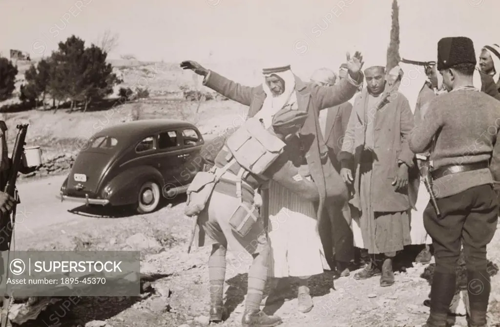 ´A British soldier searches an Arab for hidden arms, Palestine. Photograph by Zvi Orushkes (Oron). The British Mandate for Palestine, created after t...