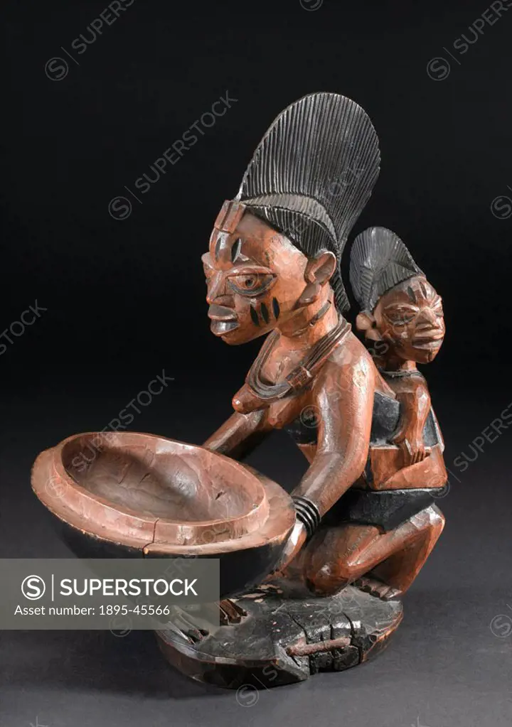 Carved adjella Ifa (Ifa ritual bowl) made by the Yoruba people, in the form of a woman carrying a child kneeling in respect to Ifa, the god of divinat...