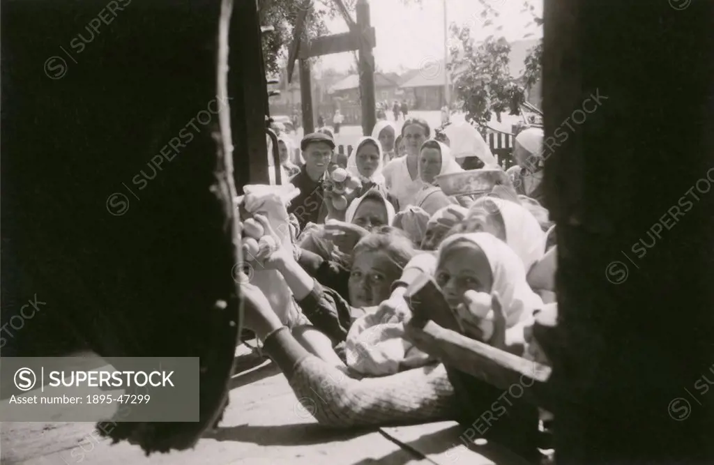 Russian peasant women, possibly in the Ukraine, crowding the door of a railway truck trying to sell eggs