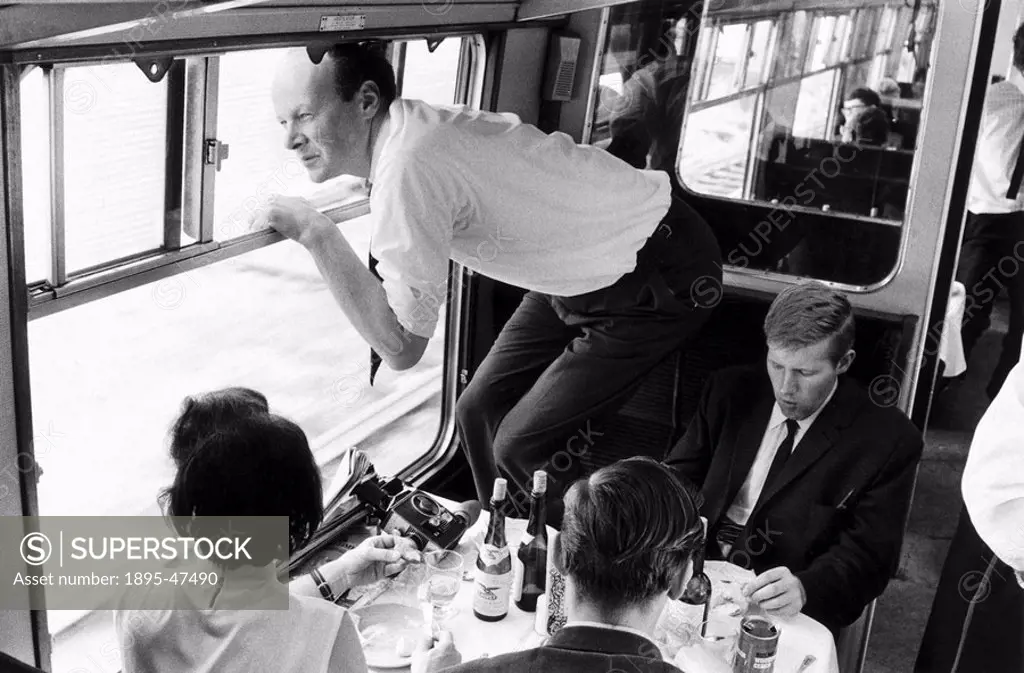 Man leaning out of a train window, 11 August 1968 An excited passenger standing on the seat in a steam train  Writing on the back of the photograph i...