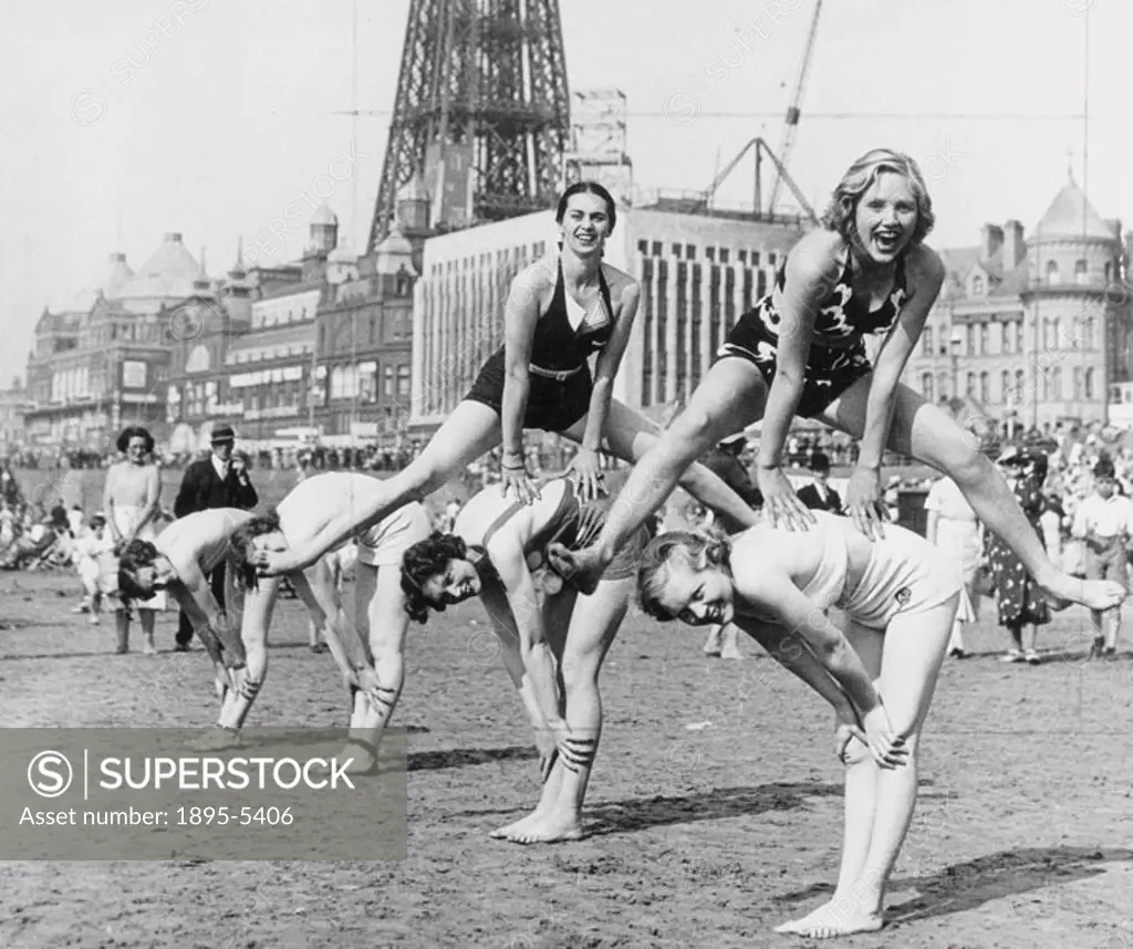 Young women playing leapfrog on the beach at Blackpool in Lancashire, 14 August 1943. Photograph by Saidman.
