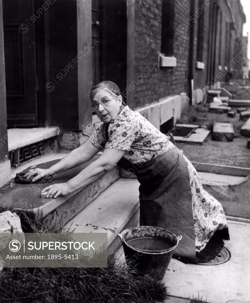 Scrubbing the doorstep, 28 September 1946. ´Housekeeper, Mrs Marie Louise Jones, aged 72, looks up from her scrubbing and made these points: ´Capital ...