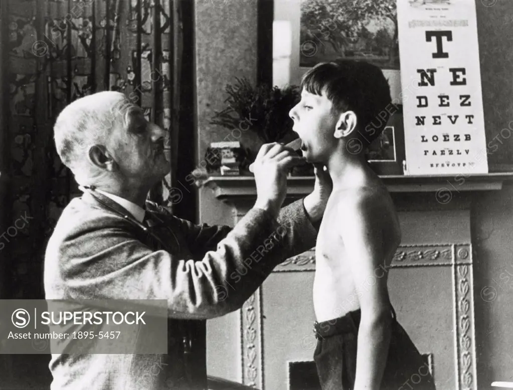 A doctor checks a boy´s tonsils during a round of school medicals.