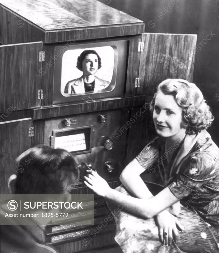 Demonstrating home television reception, 1936.his photograph was released to publicise a television test on 27th November 1936. It shows a couple watc...