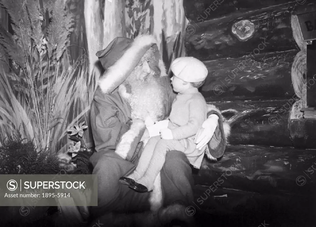 Father Christmas with a small child on his knee at Selfridges department store, London.