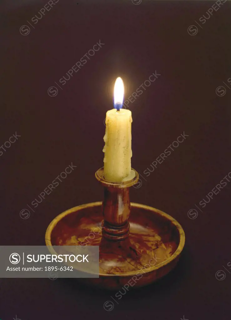 Wooden candle holder with a bowl to catch molten wax.
