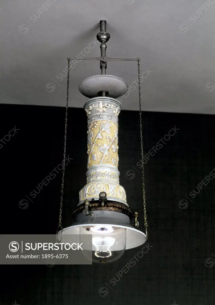 A lamp with decorative Doulton ceramic cylinder casing. The principle of the recuperative gas lamp was to use the heat generated in the lamp to warm i...
