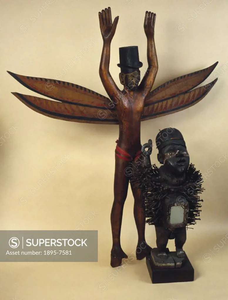 The Nicobar Island figure is a Kareau figure of carved and painted wood, anthropomorphic, representing standing male with wings and top hat, from the ...