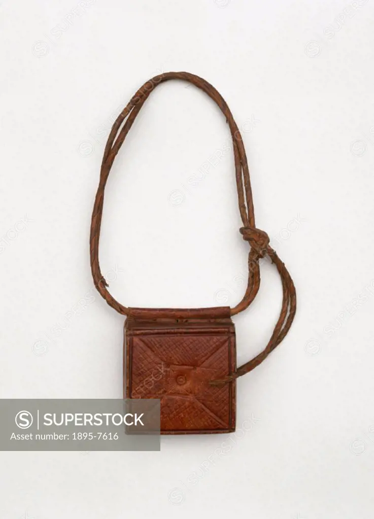 A case on a twisted leather thong. The square box is decorated with cross-hatch tooling on the front, and was used as an amulet to ward off headaches....
