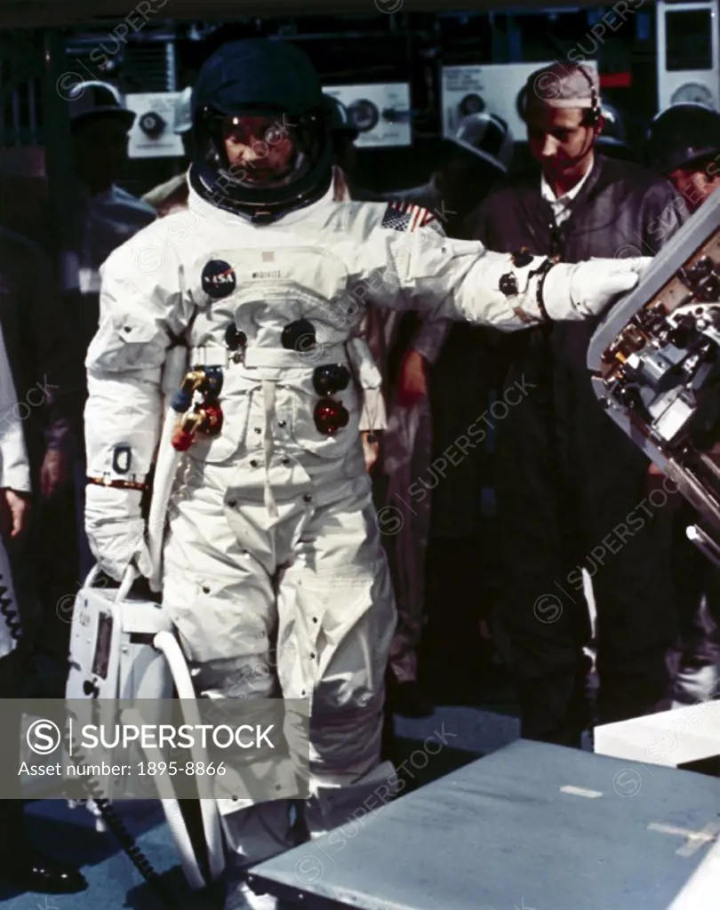 Dressed in full Apollo spacesuit, McDivitt is by the entrance hatch of an Apollo Command Module during a ground training exercise. Apollo 9 was launch...