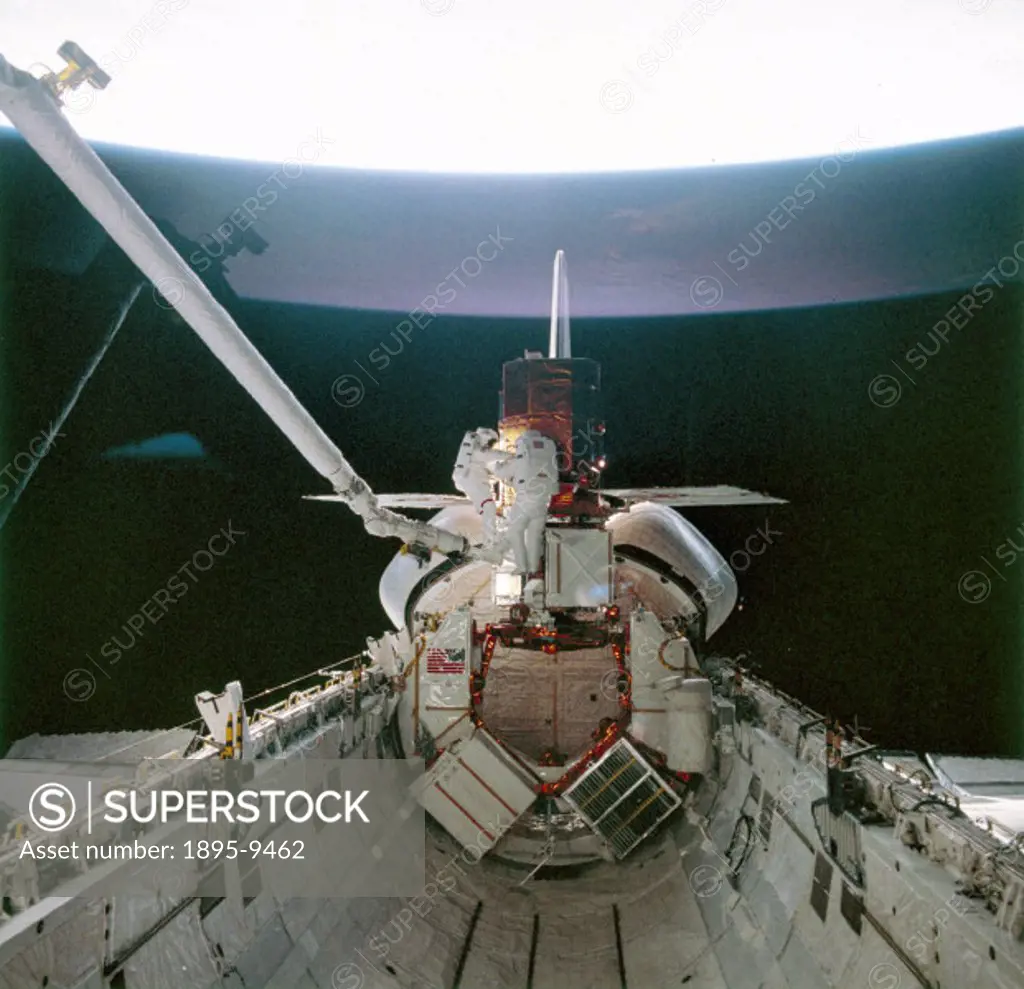 Astronauts, George Nelson and James van Hoften with the satellite in the hold of the Space Shuttle Challenger. During Shuttle mission 41-C, launched o...