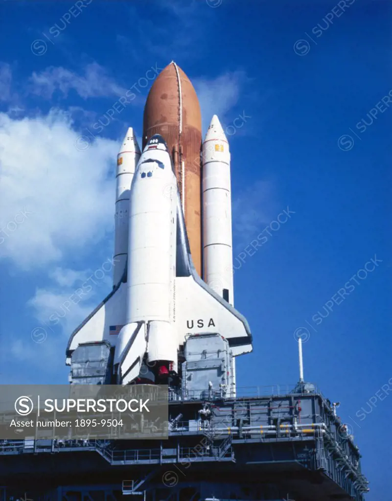 The Shuttle stands tall against the Florida sky as the Crawler Transporter negotiates the ramp of Launch Pad 39A at the Kennedy Space Centre at Cape C...