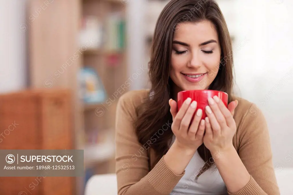 Gorgeous young woman relaxing with cup of coffee at home. Debica, Poland