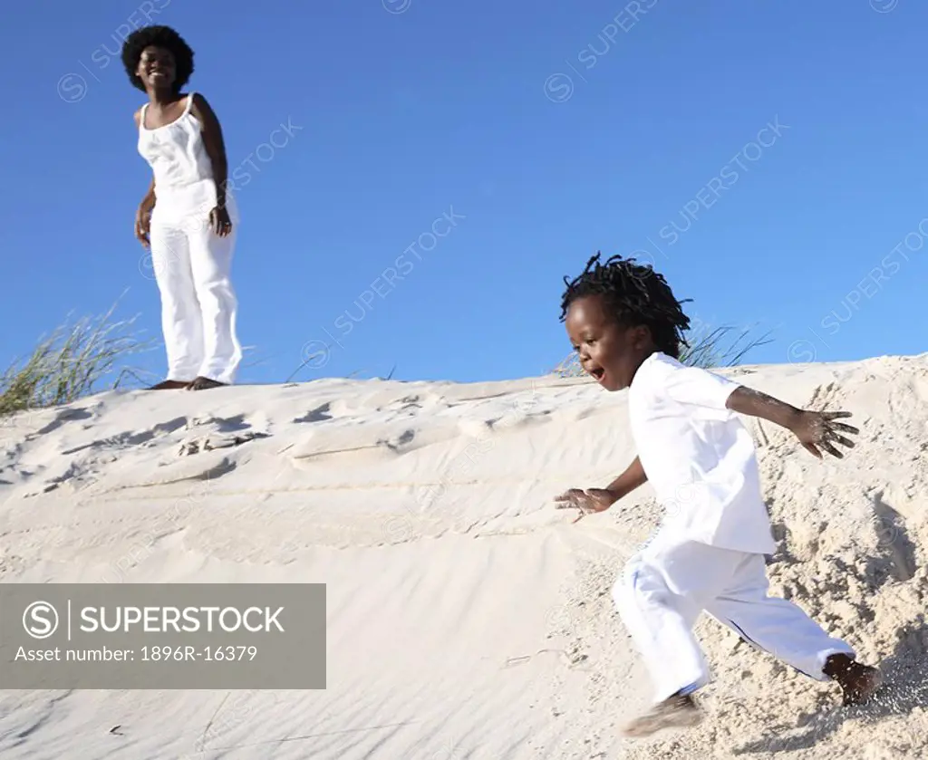Mother and son palying on sand dune, Pringle Bay, Cape Town, Western Cape Province, South Africa