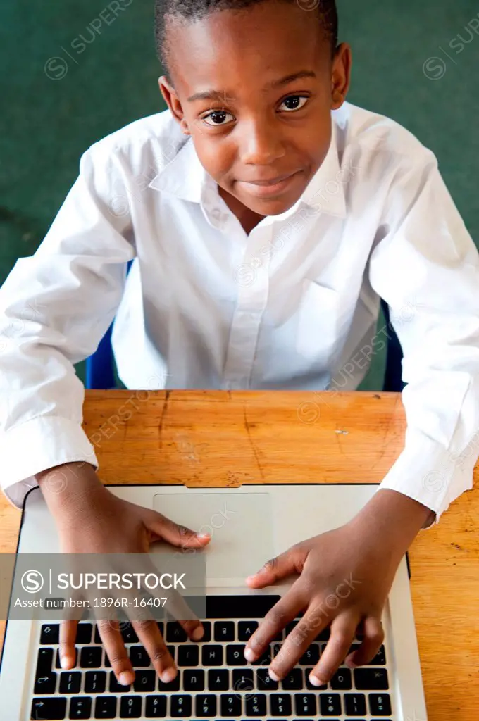Boy typing on laptop in classroom, Johannesburg, Gauteng Province, South Africa