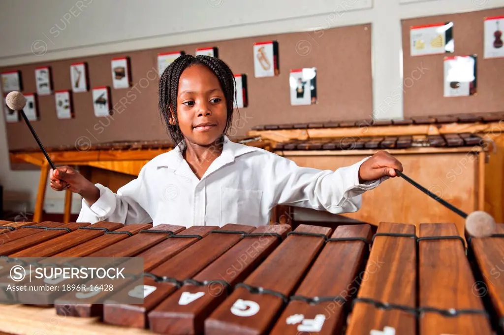 Girl playing wooden xylophone in classroom, Johannesburg, Gauteng Province, South Africa