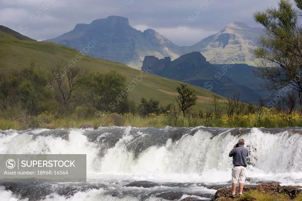 An elderly man photographing a waterfall, Drakensberg Park, KwaZulu_Natal, South Africa