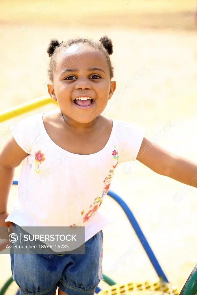 Toddler girl playing in playground and laughing, Johannesburg, South Africa