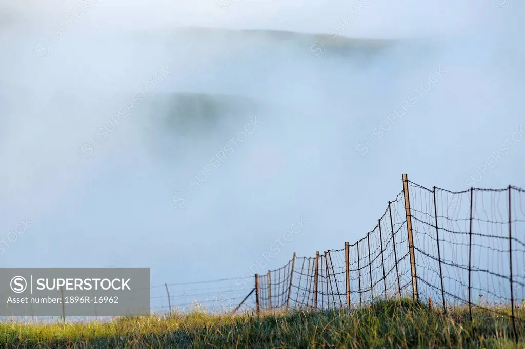 Fence line with low lying cloud behind, Witsieshoek, Free State, South Africa