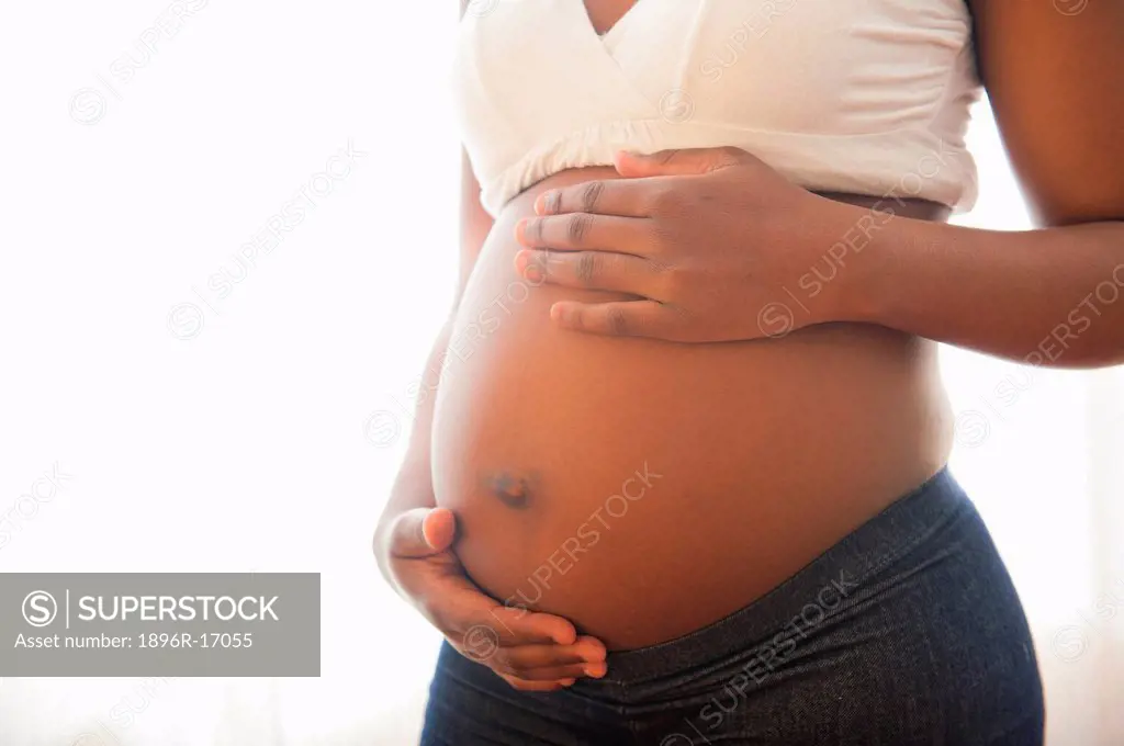 Close_up view of woman´s hands cradling pregnant stomach, Johannesburg, Gauteng Province, South Africa
