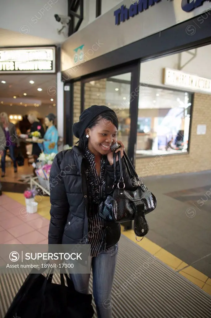 A young woman talking on her cellphone in a shopping center, Pietermaritzburg, KwaZulu_Natal, South Africa