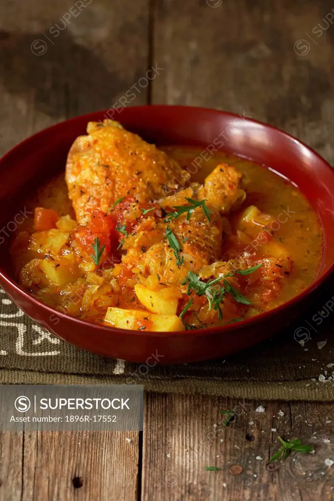 Traditional African cooking. Malawian spiced chicken curry. Ingredients _ chicken pieces, chili, potatoes, tomatoes and onions