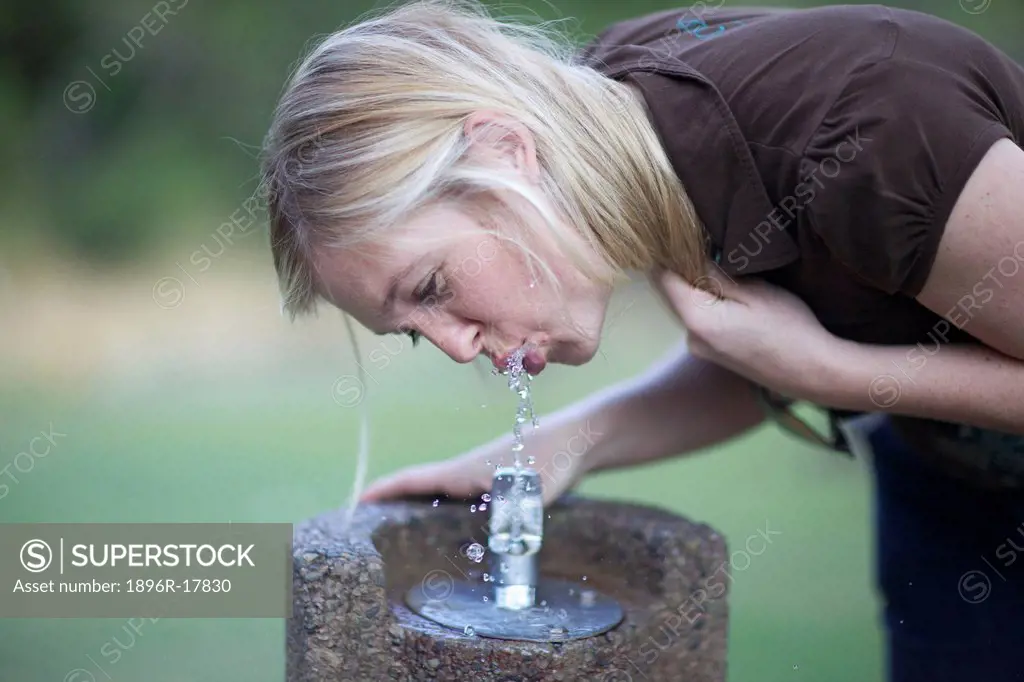 Woman drinking water from drinking fountain, Walter Sisulu Botanical Gardens, Johannesburg, Gauteng, South Africa