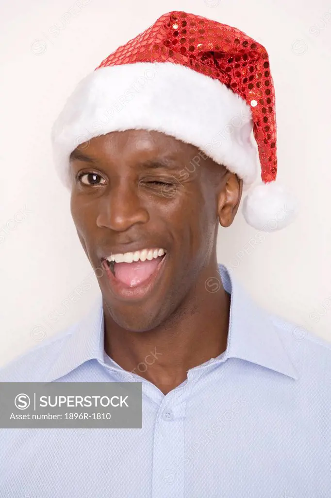 Man wearing Christmas hat, winking.