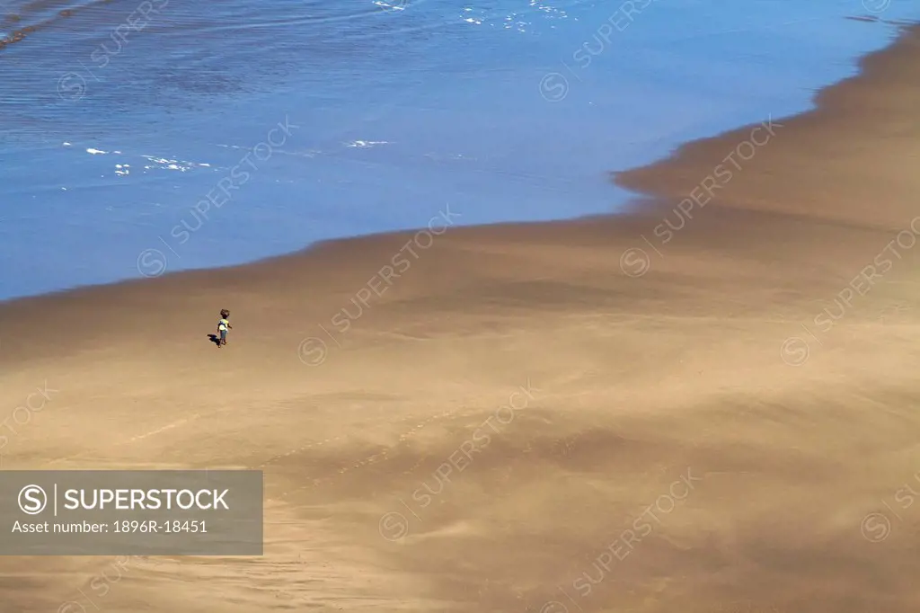 Aerial view of a woman with a child on her back walking on the beach at Port St John´s, Wild Coast, Eastern Cape, South Africa