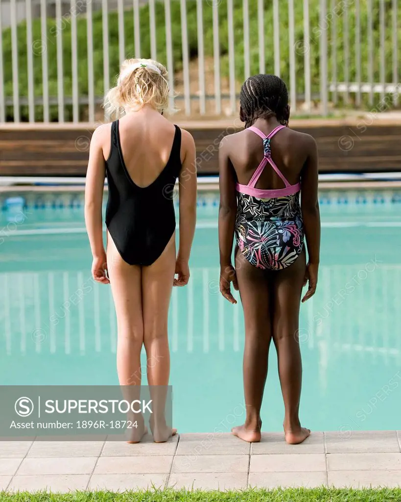 Two multi-racial girls standing on edge of pool. Windhoek, Namibia.