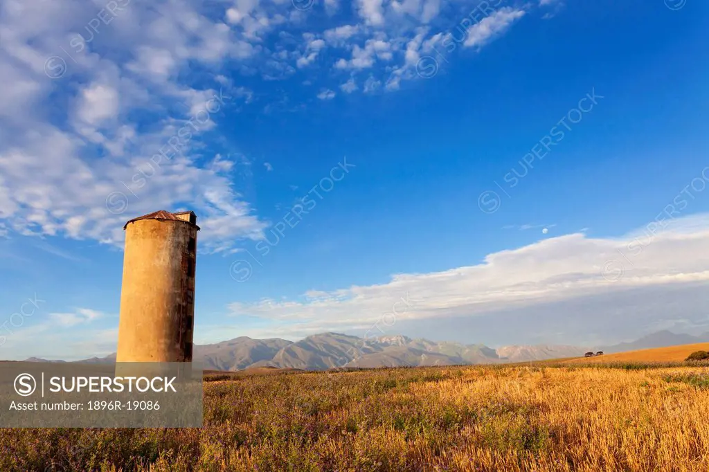 Wide angle view of an old grain silo in a harvested field. Caledon Area, Western Cape, South Africa