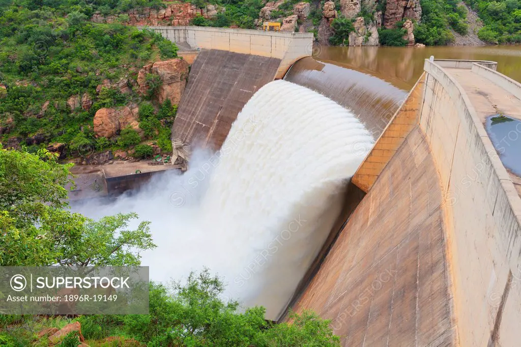 Wide angle view of water rushing over a dam wall in peak rain season. Blyde River Canyon Dam, Mpumalanga, South Africa