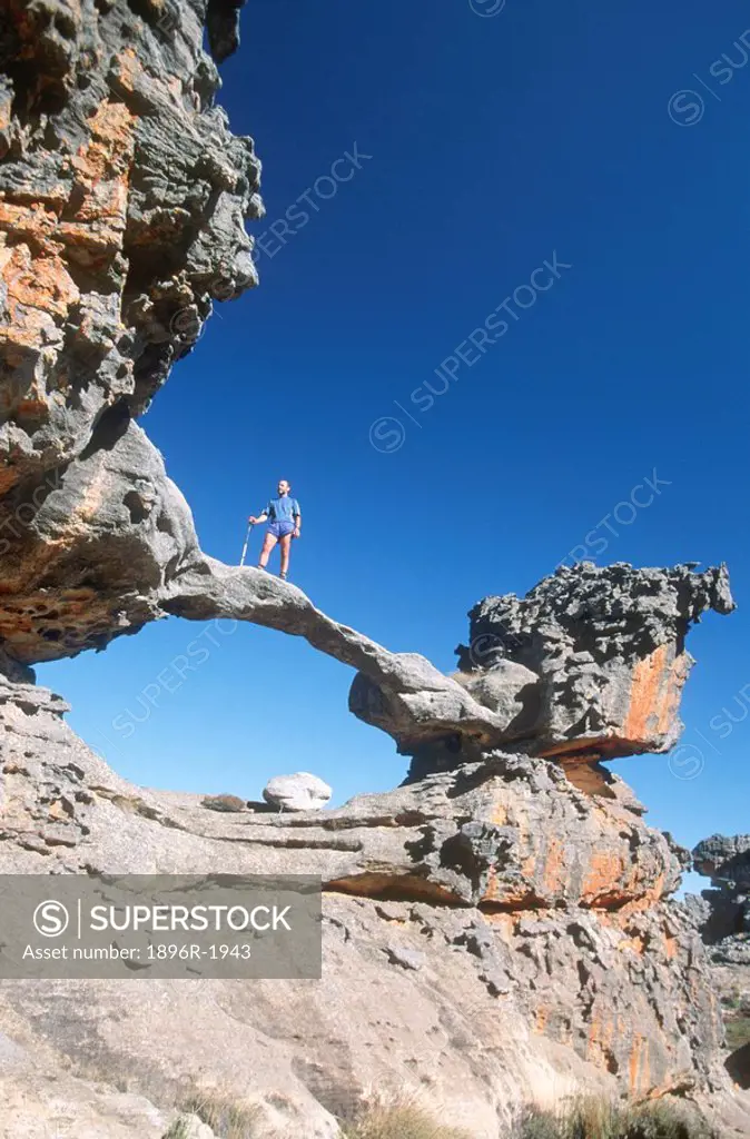 Man standing on rock arch, low angle view, Cederberg, Western Cape Province, South Africa