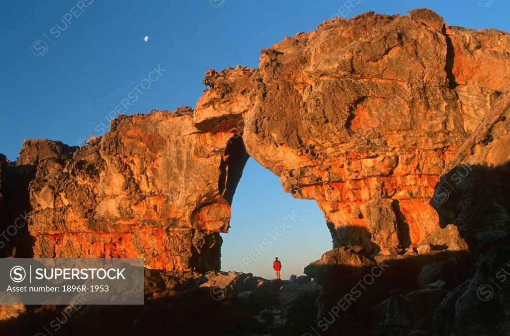 Woman standing underneath rock arch, Wolfberg Arch, Cederberg, Western Cape Province, South Africa