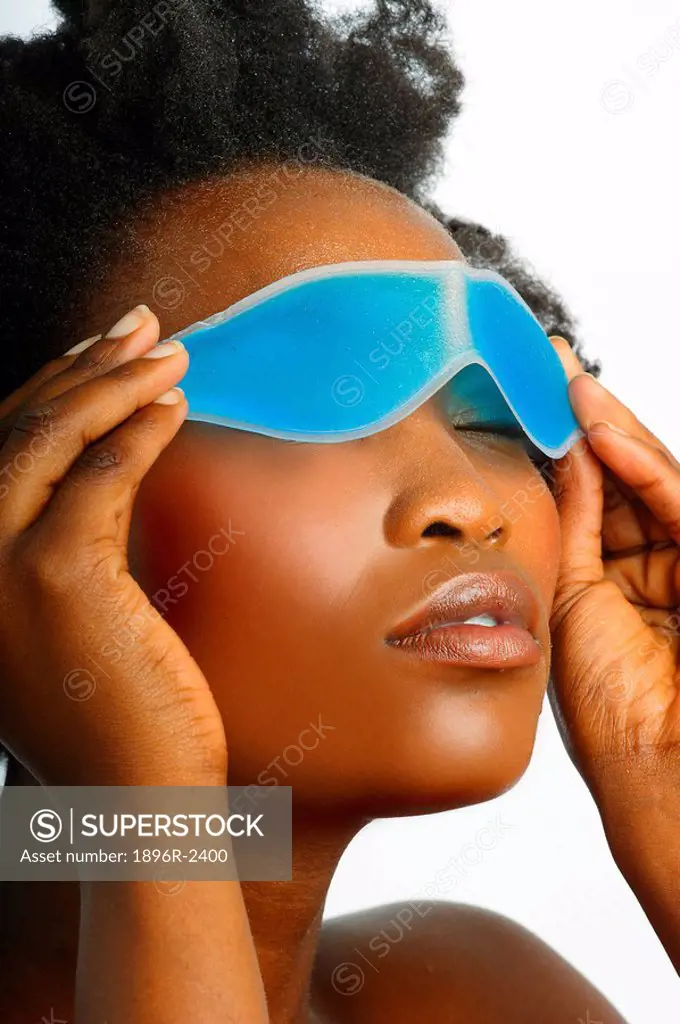 Woman Putting on an Eye Mask  Studio Shot