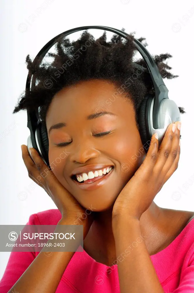 Young Woman Listening to Head Phones  Studio Shot