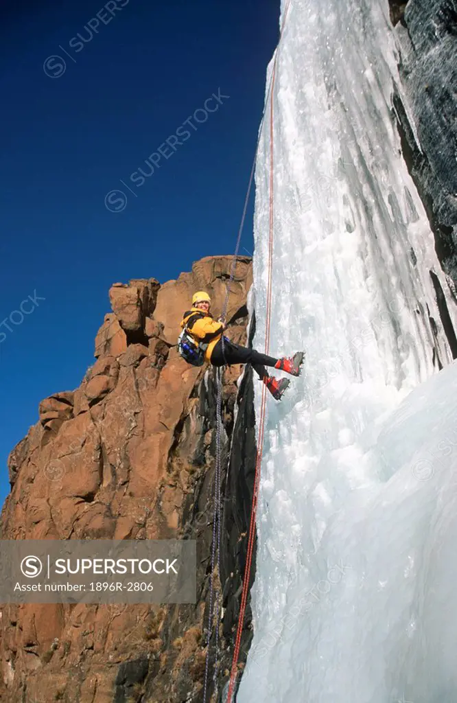 Woman Abseiling Down a Frozen Waterfall  Giants Castle Nature Reserve, Drakensberg, Freestate Province, South Africa