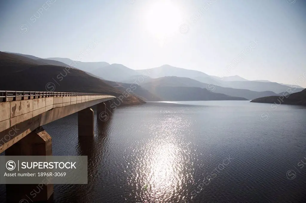 View of Bridge Going Over Katse Dam with Sun Reflecting Off Water  Katse Dam, Lesotho