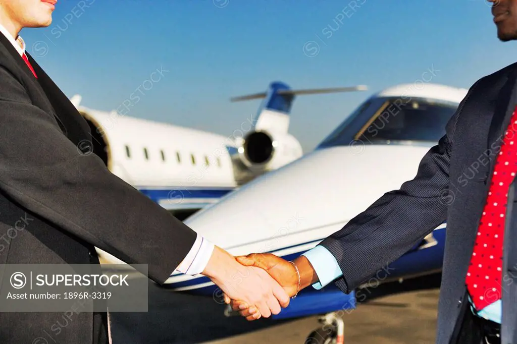 Businessmen Shaking Hands with Private Jets in the Background  Gauteng Province, South Africa